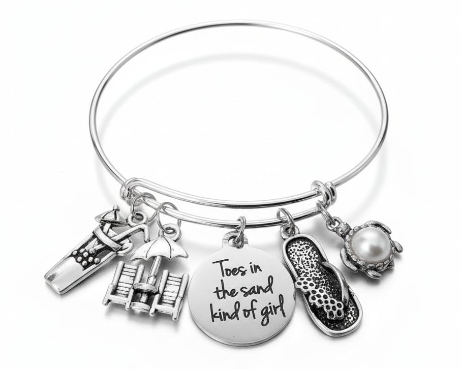 Toes in the Sand Kind of Girl silver expandable charm bangle bracelet featuring engraved disc, beach chairs with umbrella, flip flop, sea turtle with pearl, and cocktail charms — Jules Obsession handcrafted jewelry, made in USA