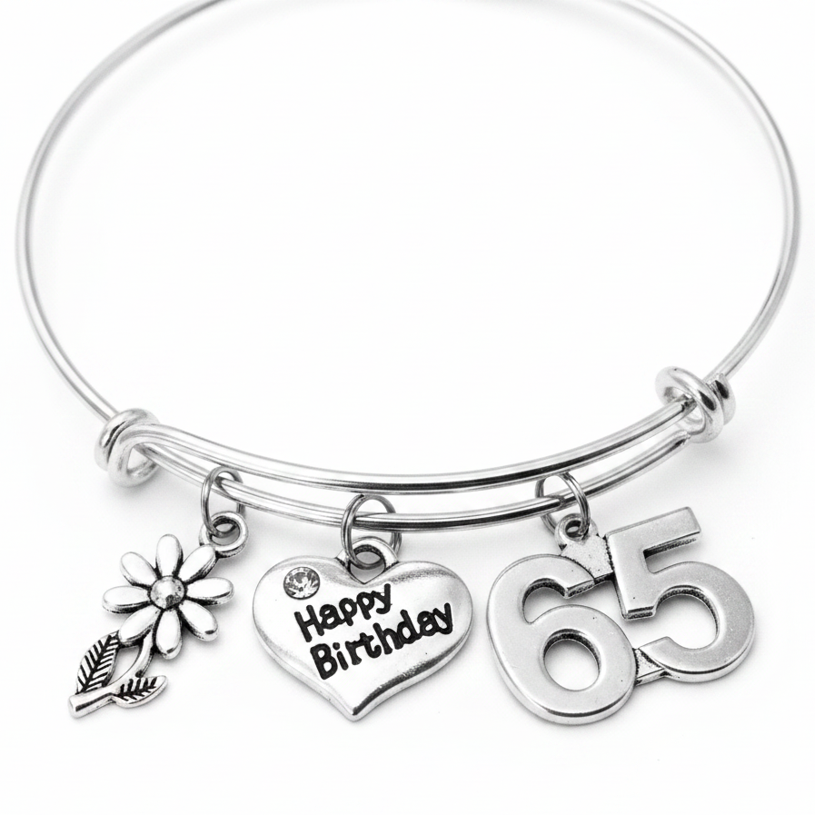 Silver bracelet with 'Happy Birthday' and number '65' charms on a white background
