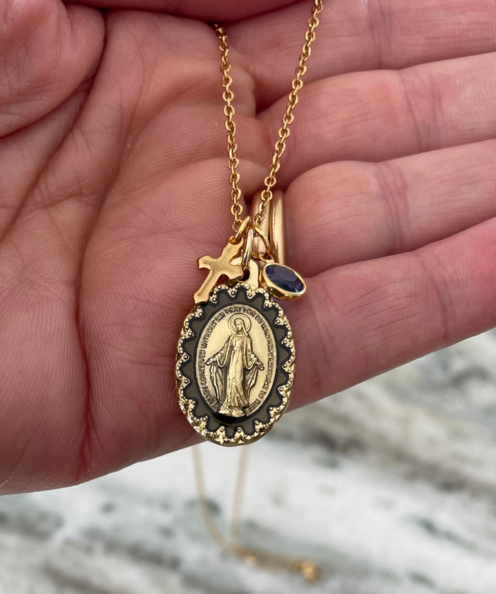 Miraculous Mary pendant with engraved prayer, gold cross, and birthstone charm on lobster clasp chain.