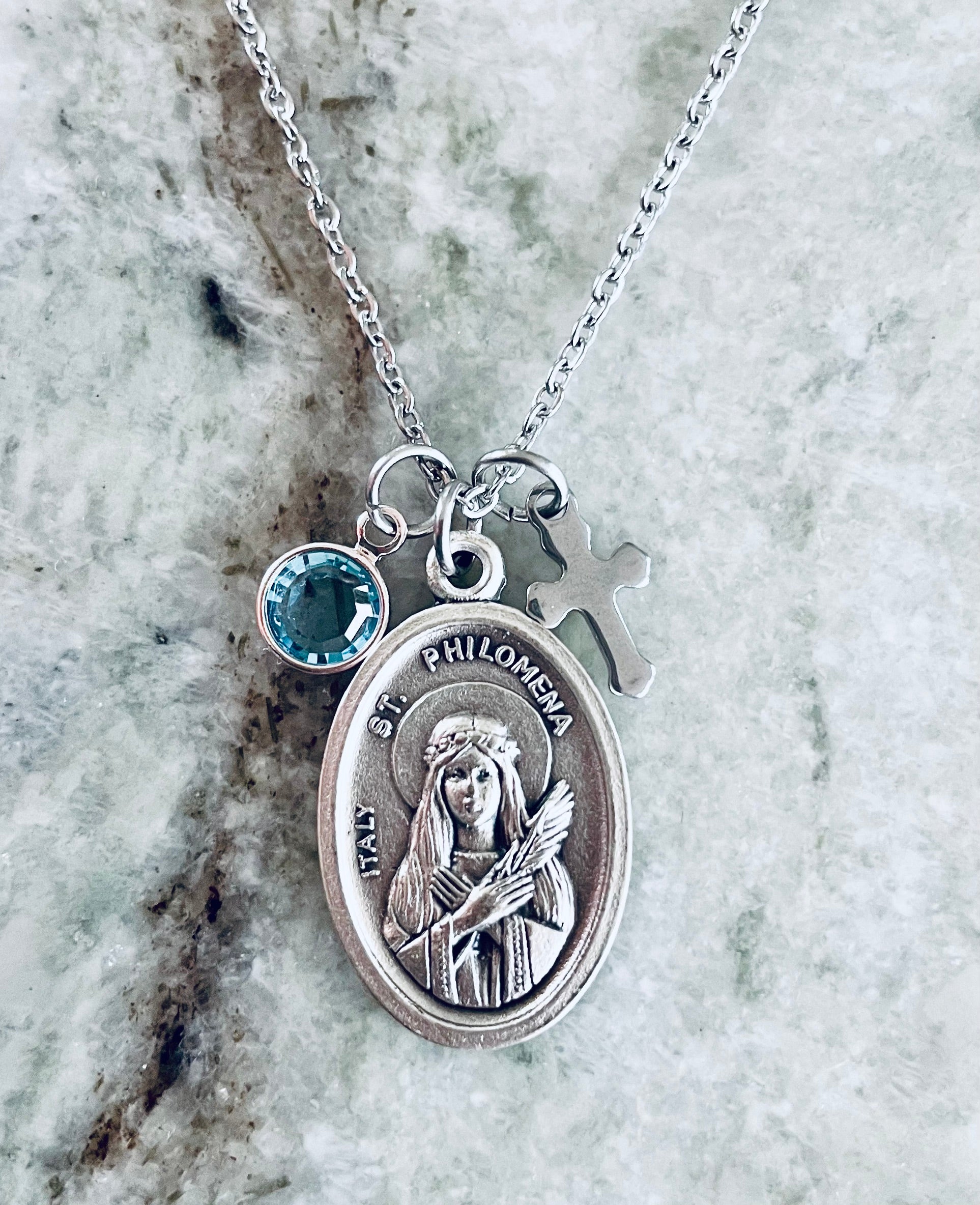 Silver Saint Philomena necklace displayed with cross and custom birthstone crystal