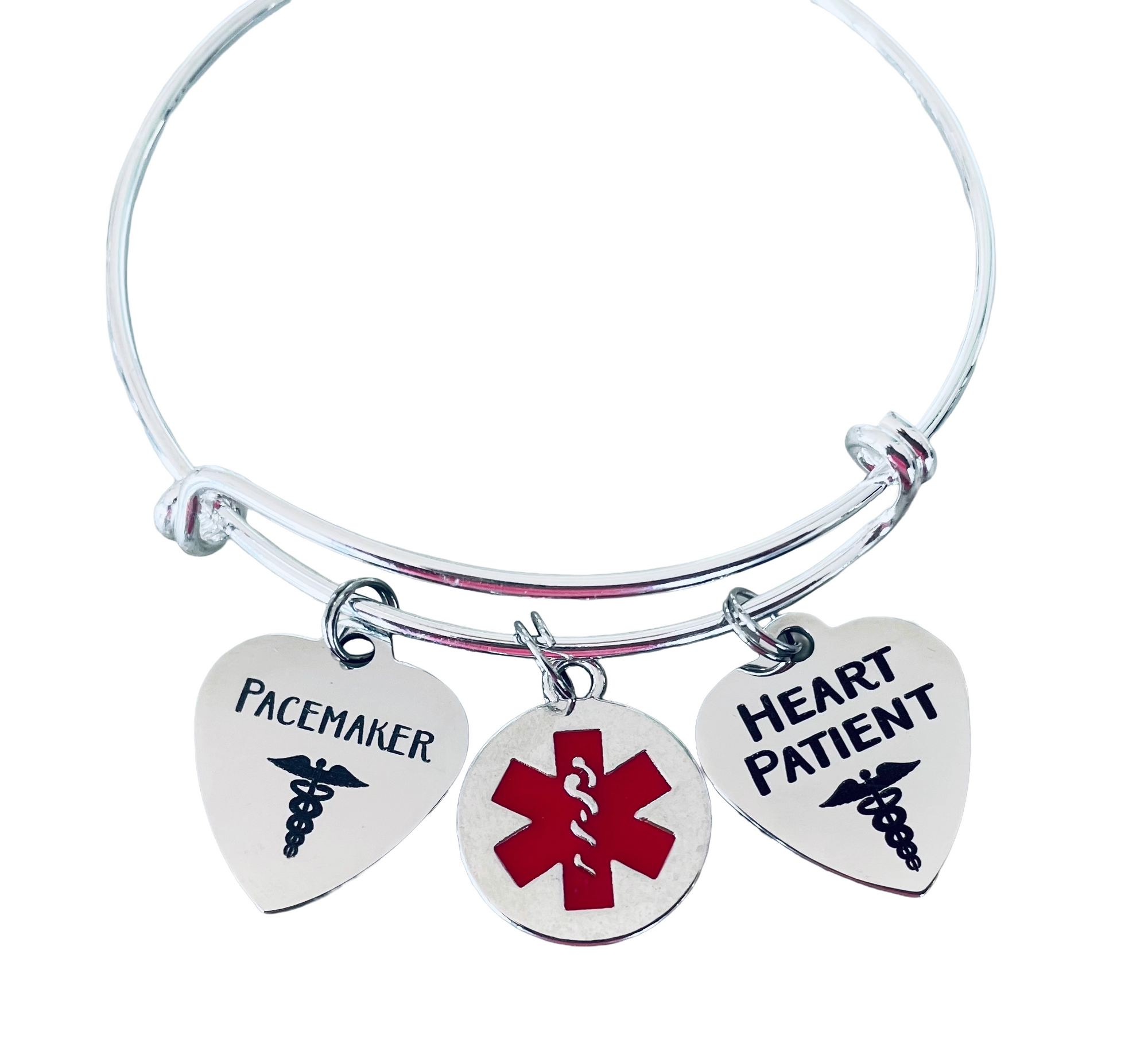 Stainless steel medical alert bangle showing heart-shaped Pacemaker and Heart Patient charms with emergency medical symbol