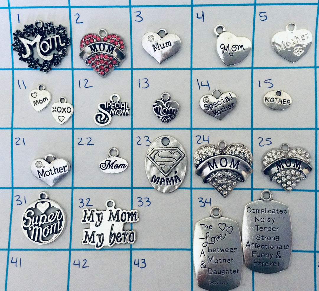Numbered silver-plated Mom and Mother charm collection for Jules Obsession expandable bangle bracelets featuring black enamel floral wreath Mom charm, pink crystal rhinestone MOM heart, silver Mum heart with crystal, engraved Mom heart, Mother heart with paw print, Mom and XOXO heart pair, Special Mom script disc, black enamel Mom heart, Special Mother crystal heart, small round Mother disc, crystal Mother heart, small oval Mom charm, Superman shield Mama oval, large crystal rhinestone MOM banner heart, cry