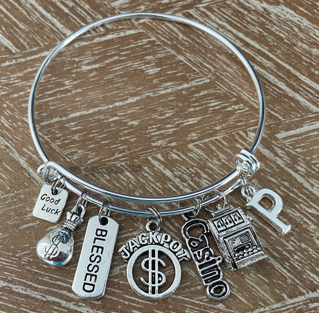 Casino Charm Bracelet with Good Luck, Money Bag, Blessed, Jackpot, Casino, and Slot Machine charms plus custom initial letter — silver expandable bangle by Jules Obsession, one size fits all