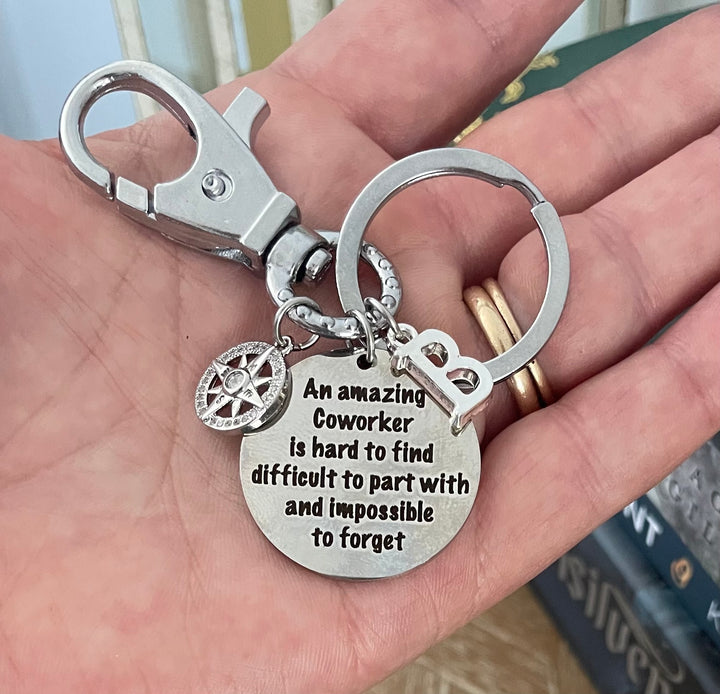 Silver keychain with swivel lobster clasp featuring an engraved coworker sentiment disc, sparkling compass rose charm, and letter initial charm