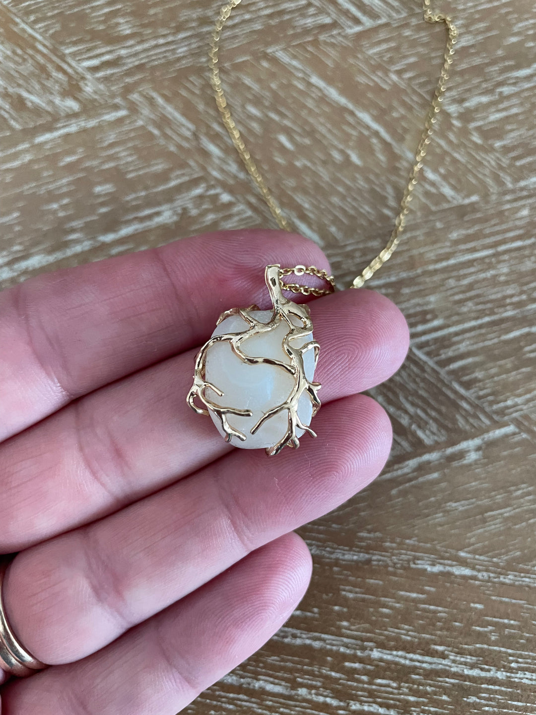 A gold necklace with a Lucky STone pendant wrapped in gold wire, 