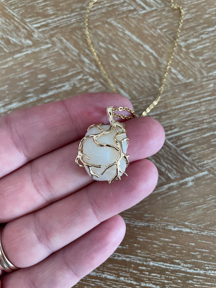 A gold necklace with a Lucky STone pendant wrapped in gold wire, 
