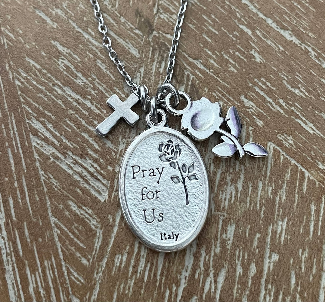 A silver-toned necklace with a round pendant engraved &