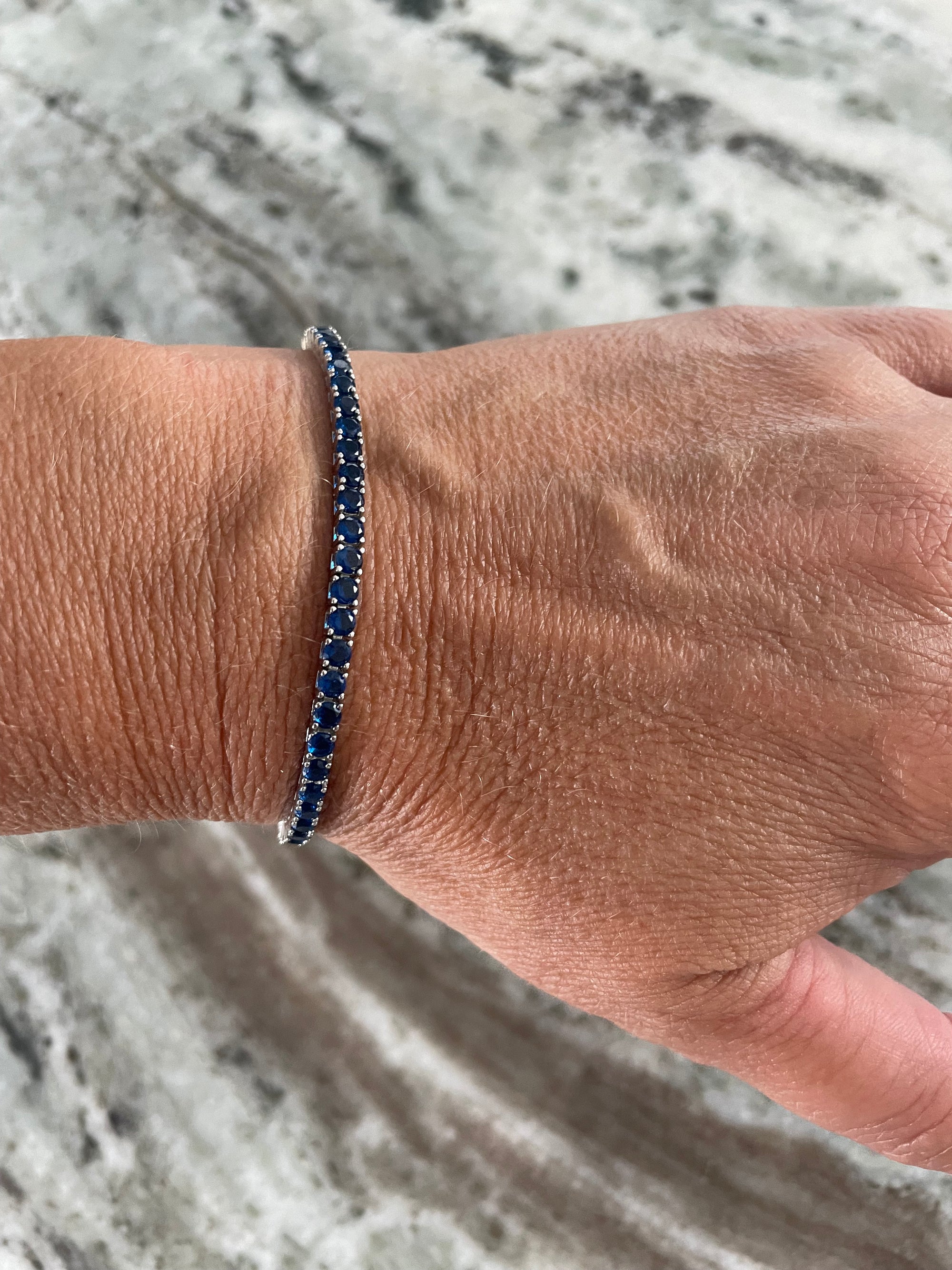 925 sterling silver bracelet featuring blue sapphires, designed with a safety clasp and luxe platinum plating
