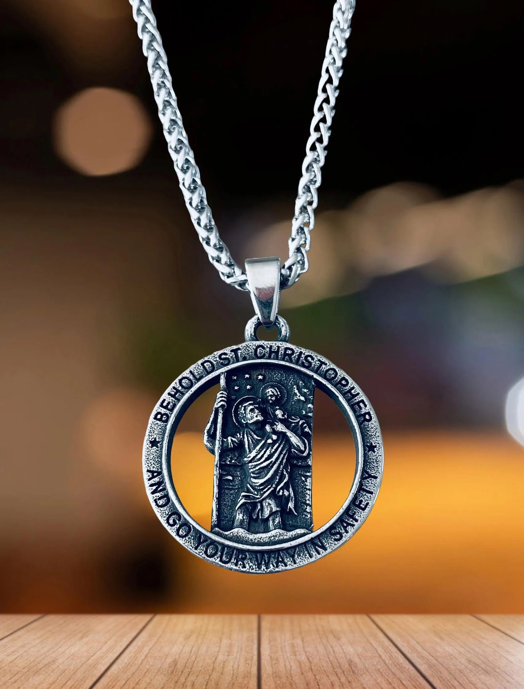stainless steel Saint Christopher medal necklace with 31mm pendant on a 24-inch chain, held in hand, symbolizing travel protection