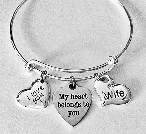 Silver bracelet with heart-shaped charms on a light gray background