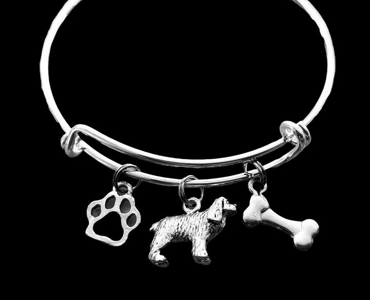 Silver-plated expandable wire bangle bracelet with three charms: cutout paw print charm, detailed 3D Cocker Spaniel dog figurine charm, and double-sided dog bone charm — meaningful gift for dog moms and Cocker Spaniel lovers