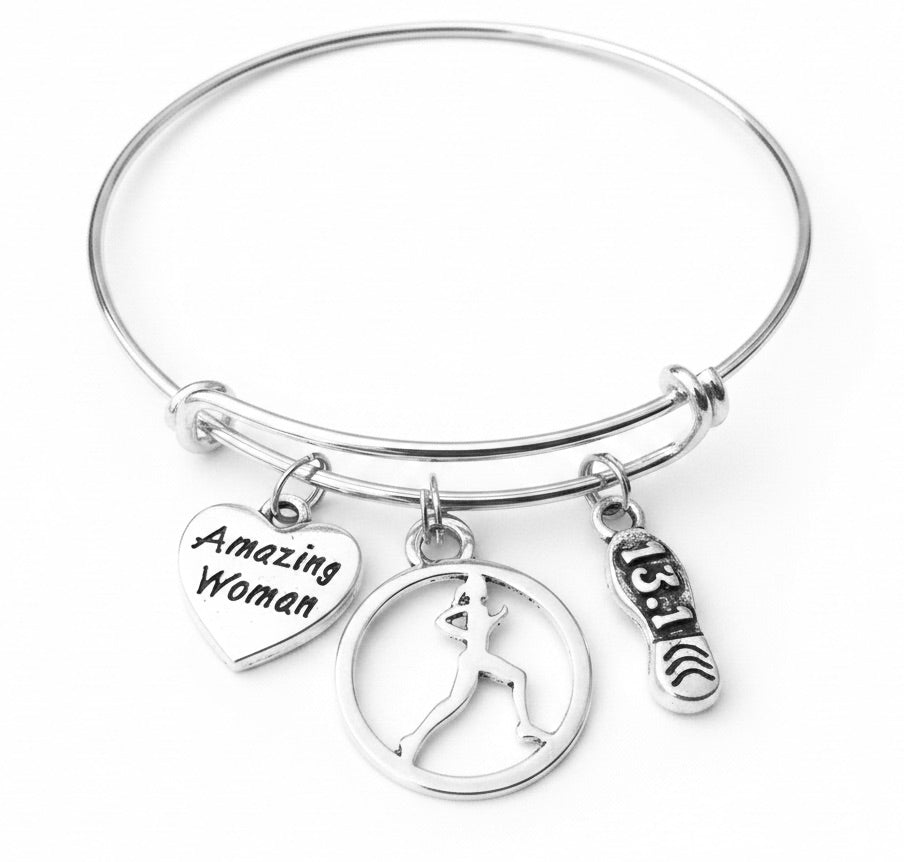 Silver expandable bangle bracelet with Amazing Woman heart charm, female runner silhouette circle charm, and 13.1 running shoe charm on white background — half marathon gift for her by Jules Obsession"