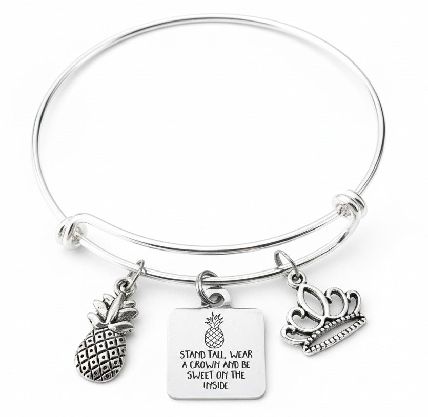 Silver expandable charm bangle bracelet with 3D silver pineapple charm, engraved Stand Tall Wear a Crown Be Sweet on the Inside square tag charm, and silver tiara princess crown charm — inspirational empowerment gift bracelet by Jules Obsession
