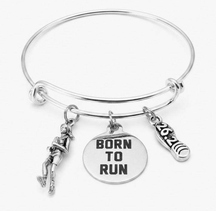 Silver expandable bangle bracelet with 3D female runner figurine charm, Born to Run disc charm, and 26.2 running shoe charm on white background — marathon finish line gift for her by Jules Obsession"