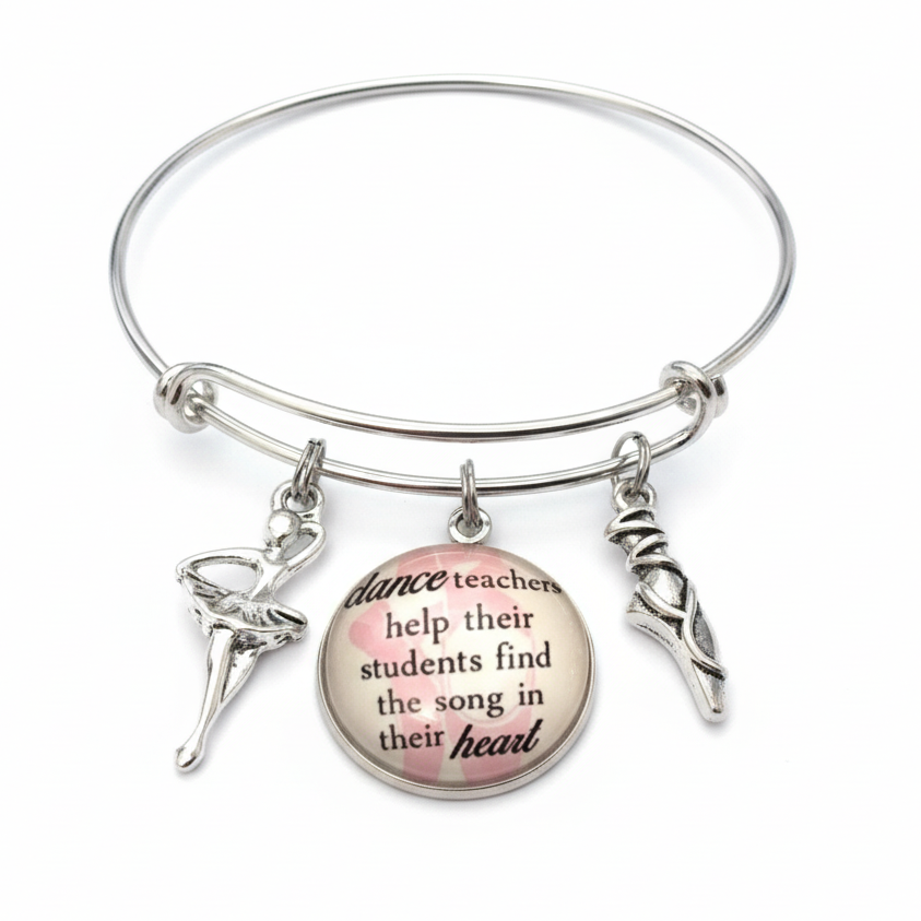 Silver bracelet with a round charm featuring text and ballet dancer charms on a white background