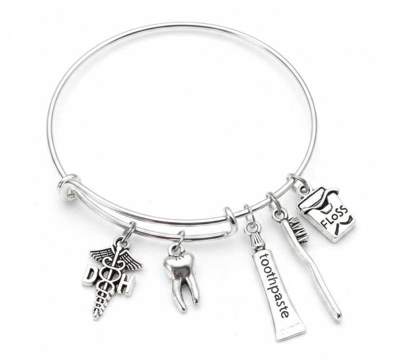 Silver expandable bangle bracelet with dental hygienist DHO caduceus charm, 3D molar tooth charm, toothbrush charm, toothpaste tube charm, and dental floss charm — dental hygienist and dentist gift bracelet by Jules Obsession