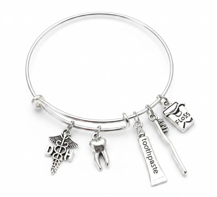 Silver expandable bangle bracelet with dental hygienist DHO caduceus charm, 3D molar tooth charm, toothbrush charm, toothpaste tube charm, and dental floss charm — dental hygienist and dentist gift bracelet by Jules Obsession