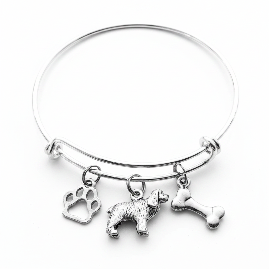 Silver-plated expandable wire bangle bracelet with three charms: cutout paw print charm, detailed 3D Cocker Spaniel dog figurine charm, and double-sided dog bone charm — meaningful gift for dog moms and Cocker Spaniel lovers