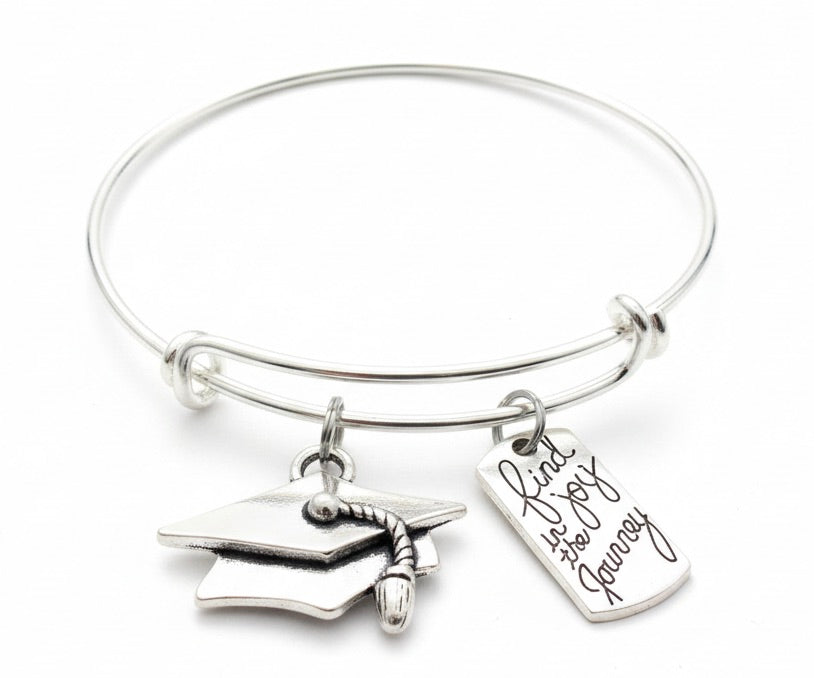 Silver expandable charm bangle bracelet with 3D graduation cap charm with tassel and engraved Find Joy in the Journey rectangular dog tag charm in cursive script — graduation gift bracelet by Jules Obsession