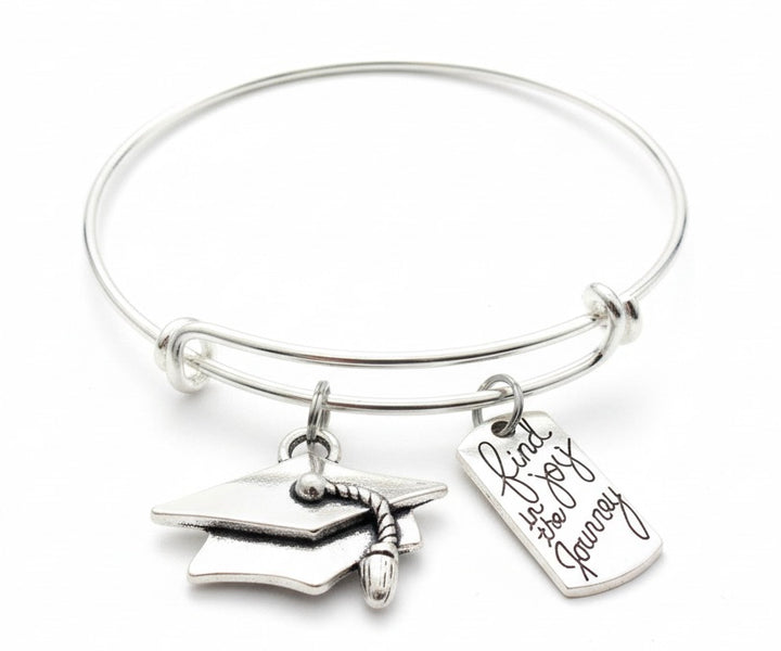 Silver expandable charm bangle bracelet with 3D graduation cap charm with tassel and engraved Find Joy in the Journey rectangular dog tag charm in cursive script — graduation gift bracelet by Jules Obsession