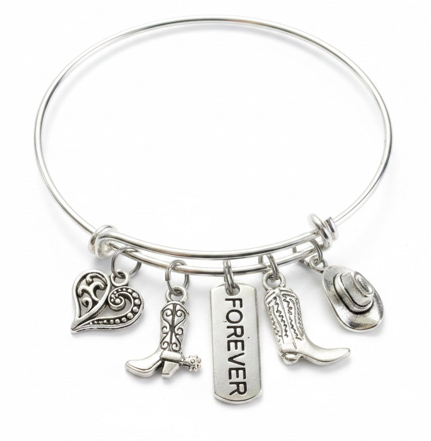 Silver forever country western charm bangle bracelet on white background featuring filigree heart charm, cowboy boots charm, Forever tag charm, cowboy boot charm and cowboy hat charm,