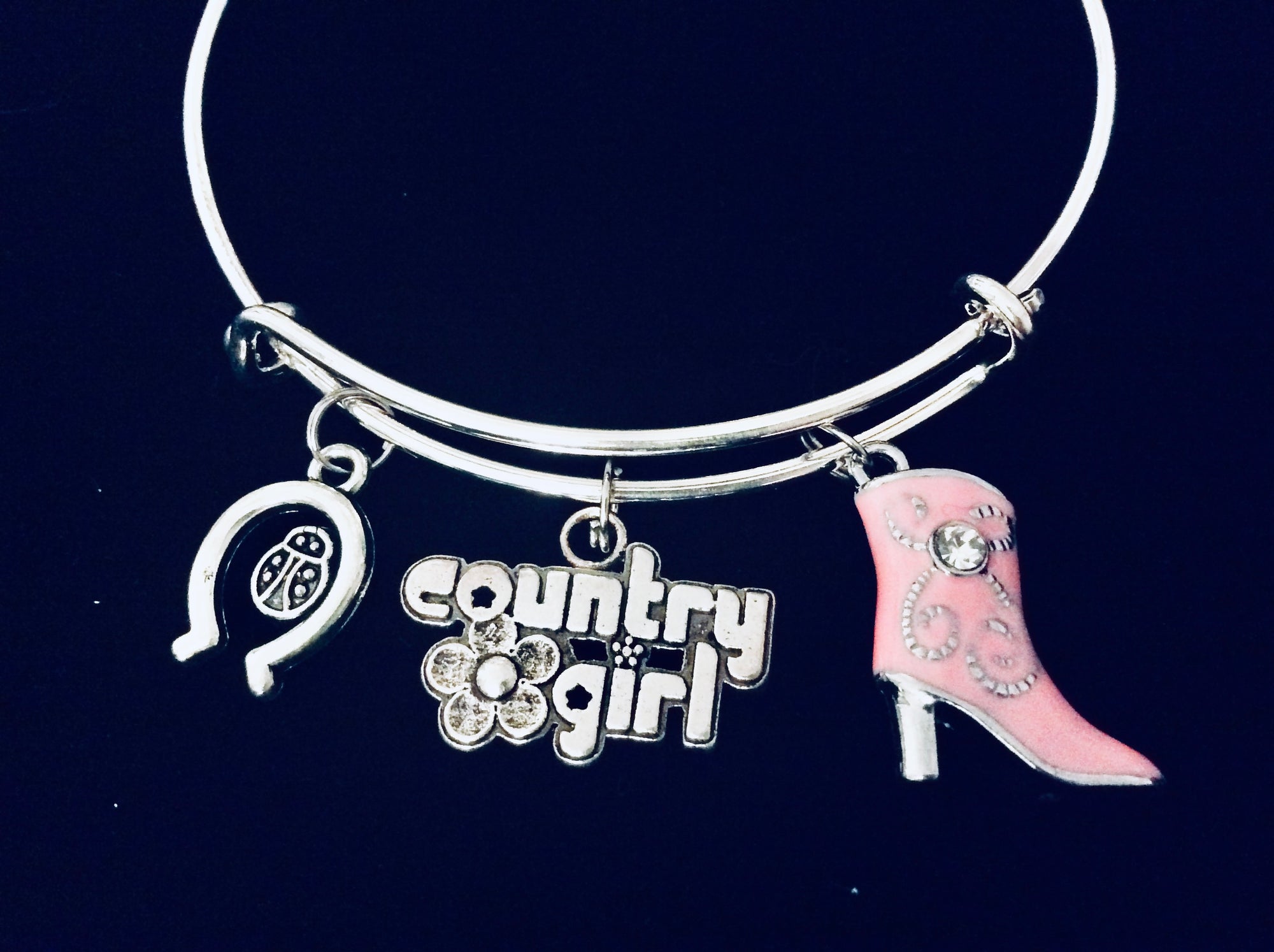 Expandable silver country girl charm bracelet with pink cowboy boot, horseshoe, and ladybug charms
