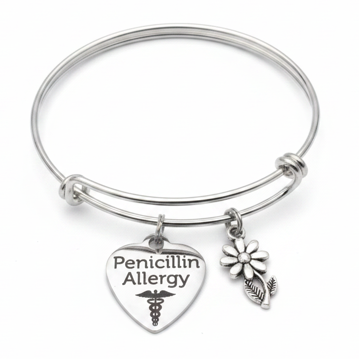 Silver expandable bangle bracelet with Penicillin Allergy heart charm and daisy flower charm attached with jump rings, studio photo on white background