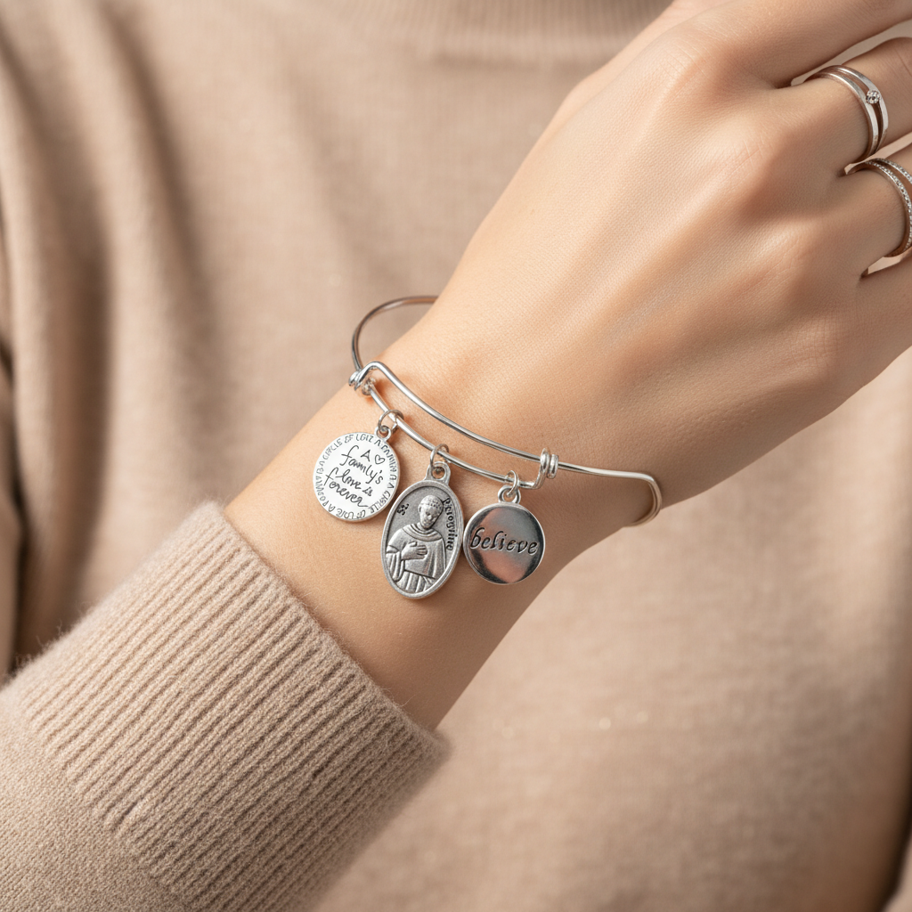 Woman wearing St. Peregrine Catholic charm bracelet on wrist — faith jewelry gift for cancer patient