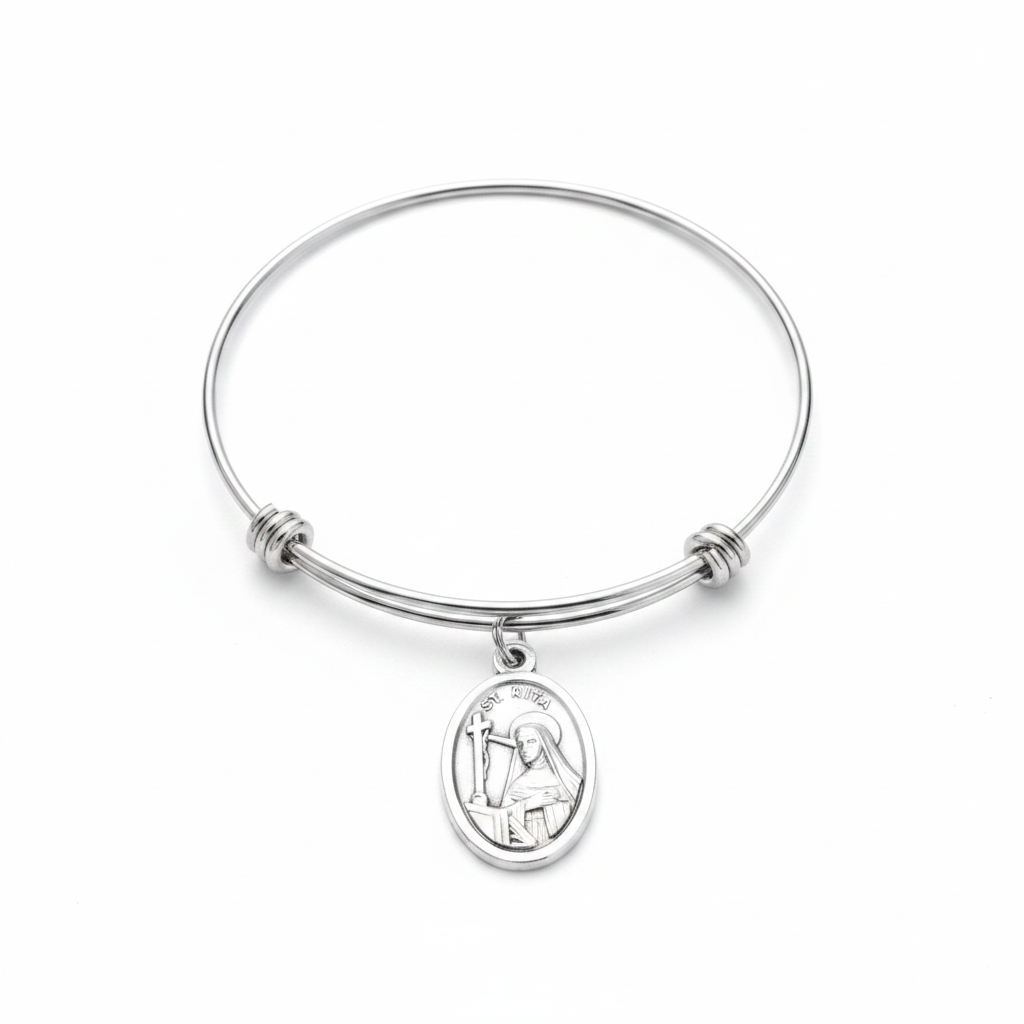 Saint Rita patron saint bangle bracelet with silver oxidized oval medal charm on adjustable stainless steel wire bangle, studio photo on white background