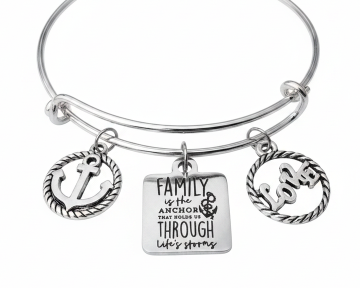 Silver expandable bangle bracelet with three charms: rope-border anchor charm, engraved square tag reading Family is the Anchor That Holds Us Through Life&