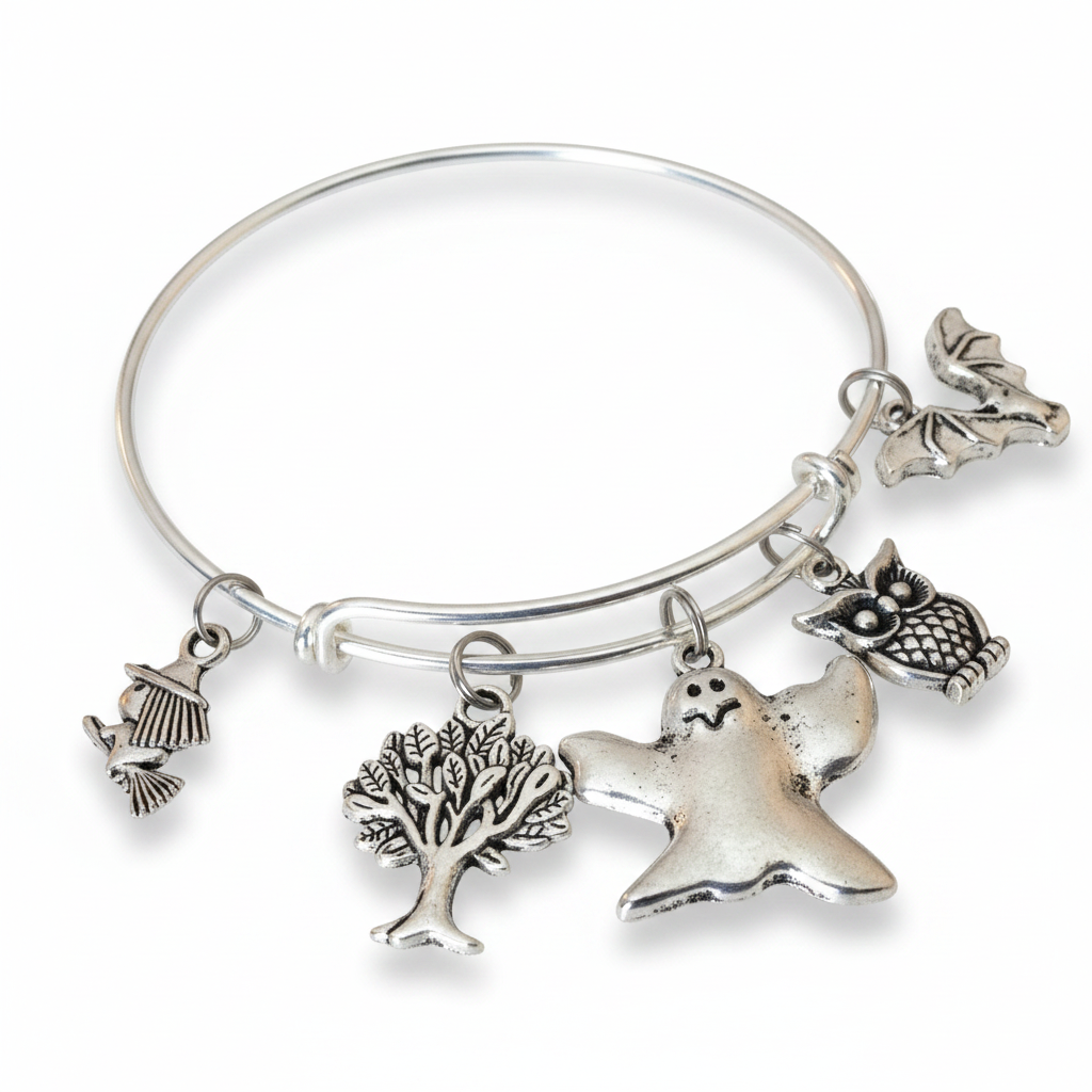 Silver expandable wire bangle bracelet on white background featuring four Halloween charms: witch hat, tree of life, flying ghost, and detailed owl with feather texture