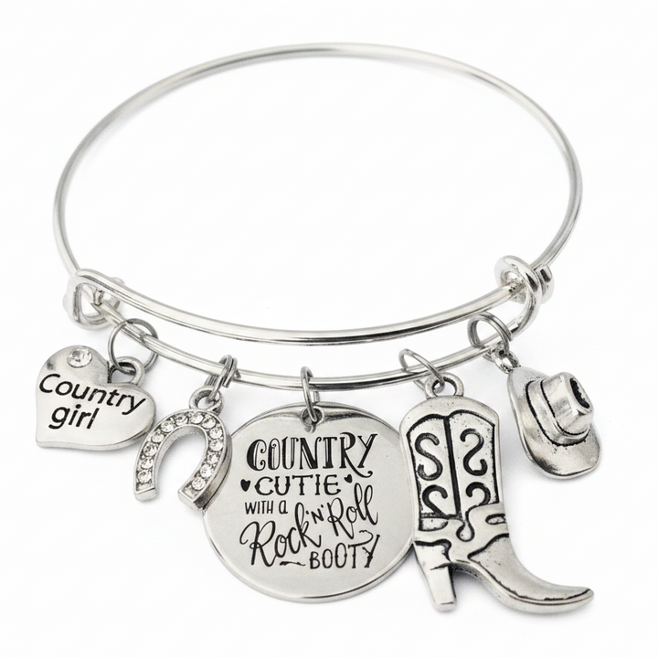 Silver expandable charm bangle bracelet with country girl heart, crystal horseshoe, cowboy boots, cowboy hat, and engraved Country Cutie disc charms on white background