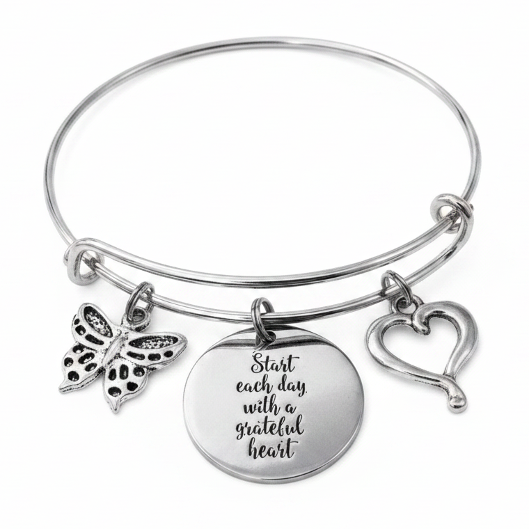 Silver expandable bangle bracelet with Start Each Day With a Grateful Heart engraved disc charm, butterfly charm, and open heart outline charm on white background – Jules Obsession inspirational gift jewelry