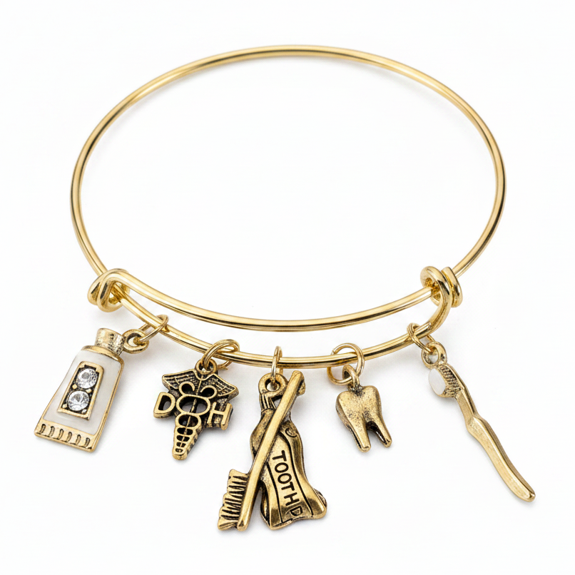Gold-tone expandable bangle bracelet with five dentistry charms — toothpaste tube, dental caduceus, tooth extraction, molar tooth, and dental pick — on white studio background