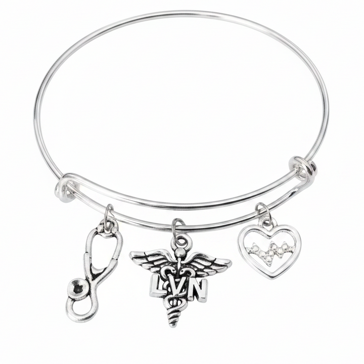 Silver expandable bangle bracelet with LVN caduceus charm, EKG heartbeat heart charm, and stethoscope charm on white background — licensed vocational nurse gift jewelry