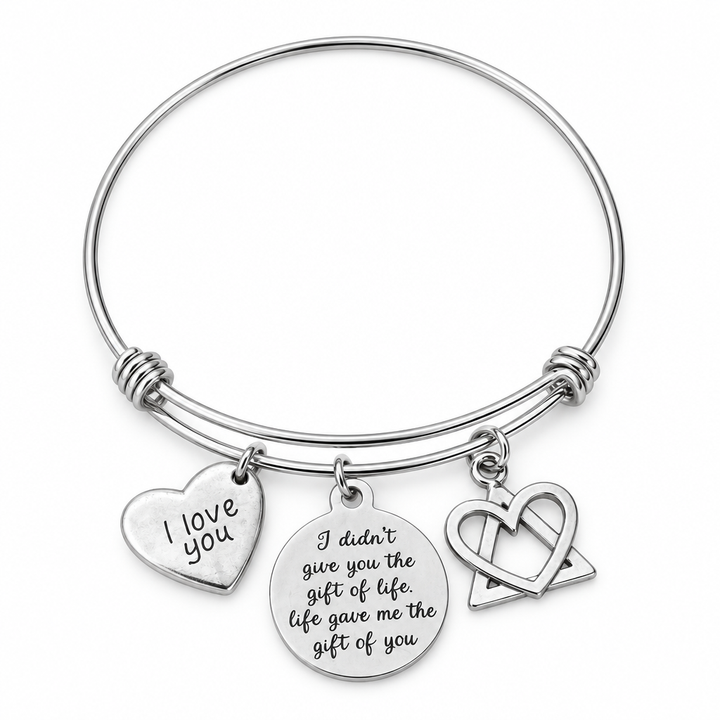 Silver bangle bracelet with I love you heart, gift of life engraved disc, and heart-and-triangle charms on white.