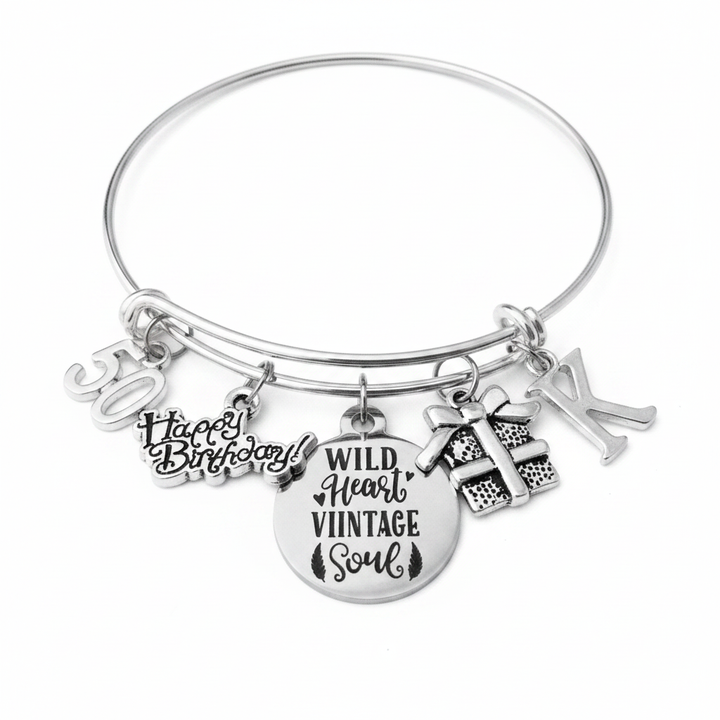 Silver expandable bangle bracelet with 50 number charm, Happy Birthday script charm, Wild Heart Vintage Soul round engraved medallion, gift box charm, and personalized initial charm — handmade by Jules Obsession