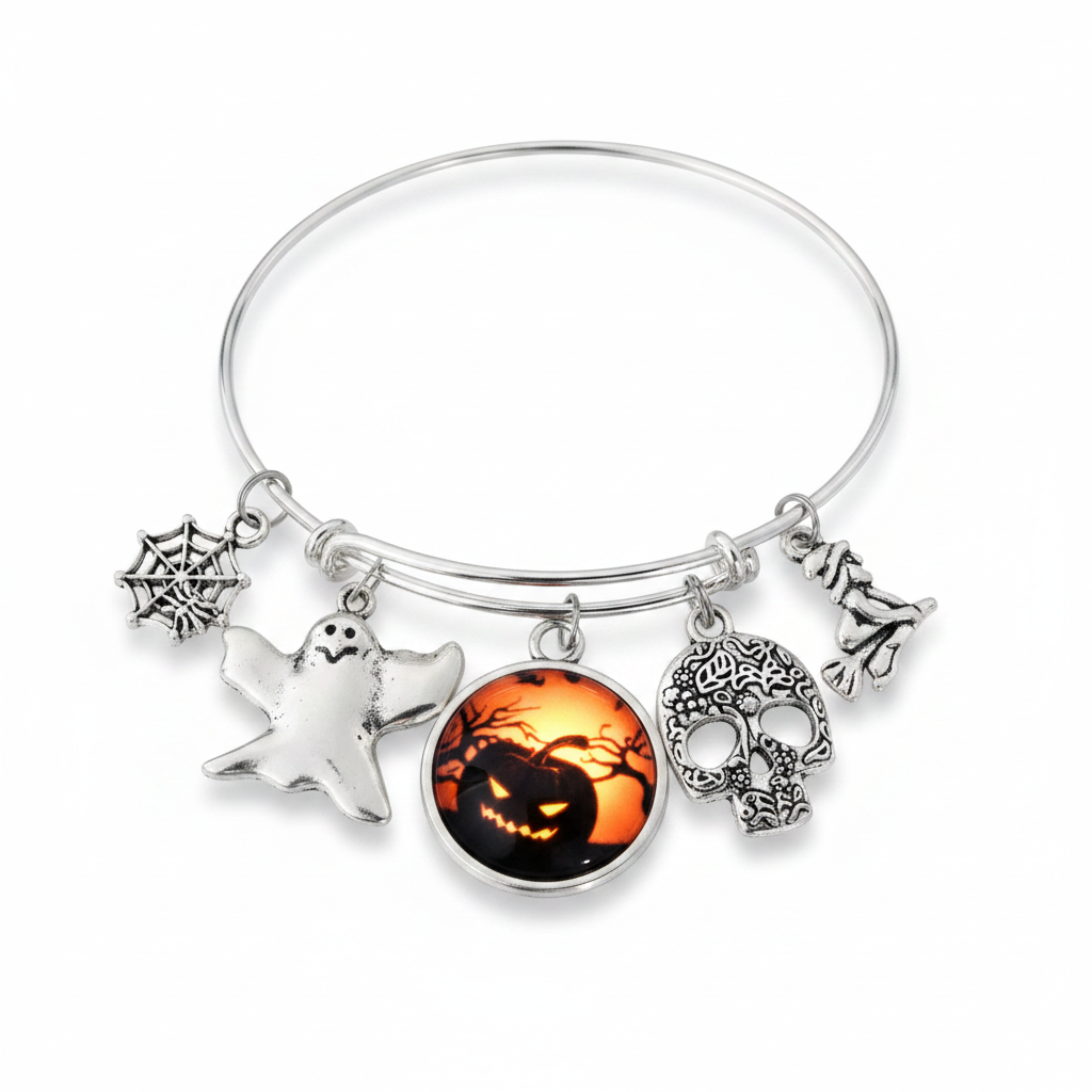 Silver expandable wire bangle bracelet on white background featuring five Halloween charms: spider web, white ghost, jack-o-lantern glass dome cabochon, floral sugar skull, and witch on broomstick