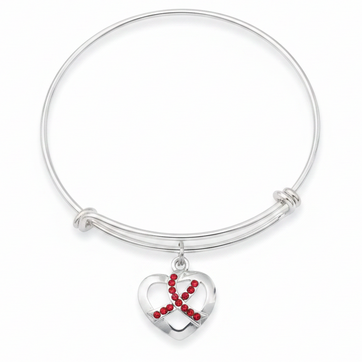 Silver expandable bangle bracelet with open-cut heart charm featuring red crystal rhinestone awareness ribbon on white background overhead view - Jules Obsession