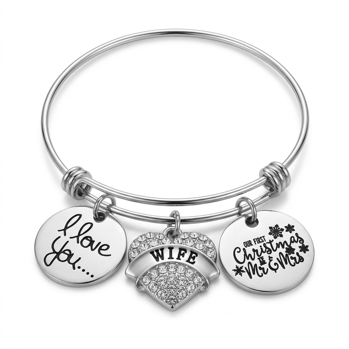 Stainless steel bangle with silver-plated I Love You disc, crystal Wife heart, and Our First Christmas as Mr and Mrs charm on white.