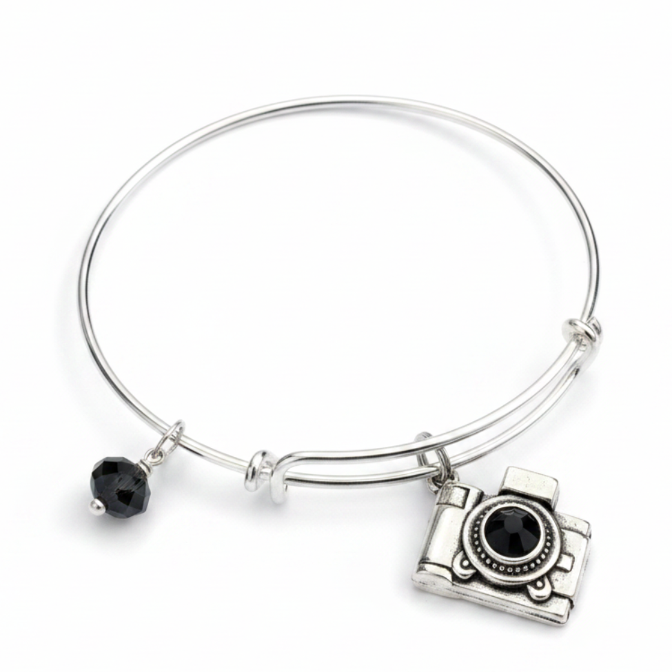 Silver expandable bangle bracelet with vintage camera charm featuring black crystal lens and faceted black crystal bead — photographer gift bracelet by Jules Obsession
