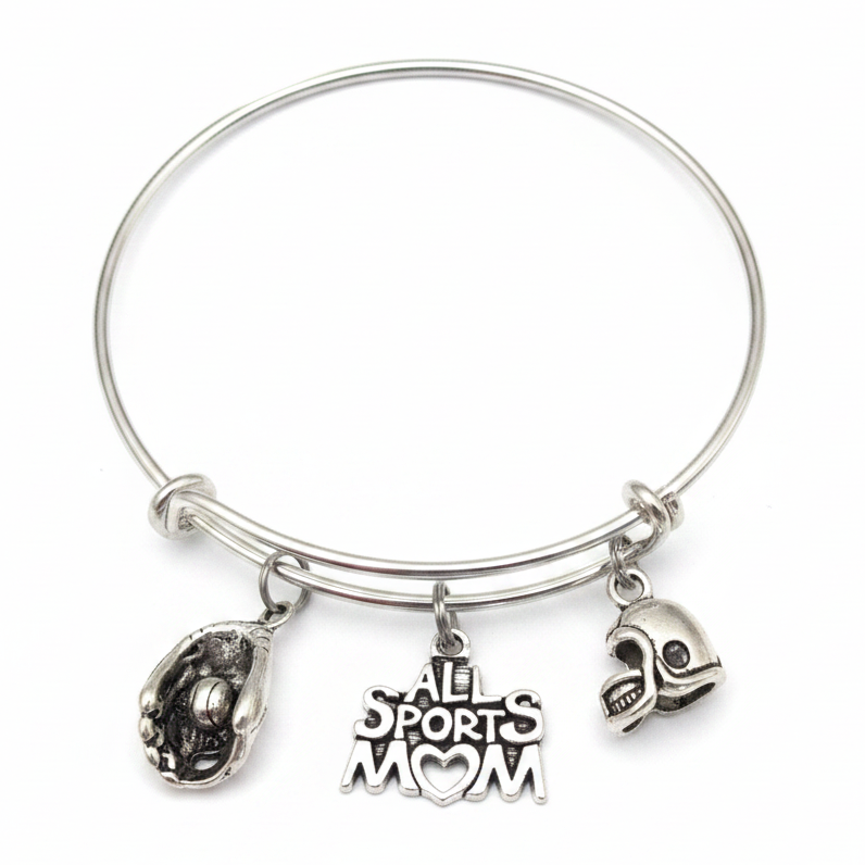 Silver expandable wire bangle bracelet with All Sports Mom heart charm, 3D football helmet charm, and baseball glove with ball charm, displayed flat on white studio background