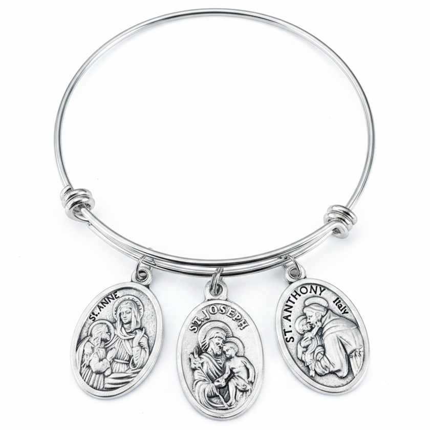Silver adjustable bangle bracelet with three antique silver oval saint medal charms — St. Anne, St. Joseph, and St. Anthony — displayed on a white studio background