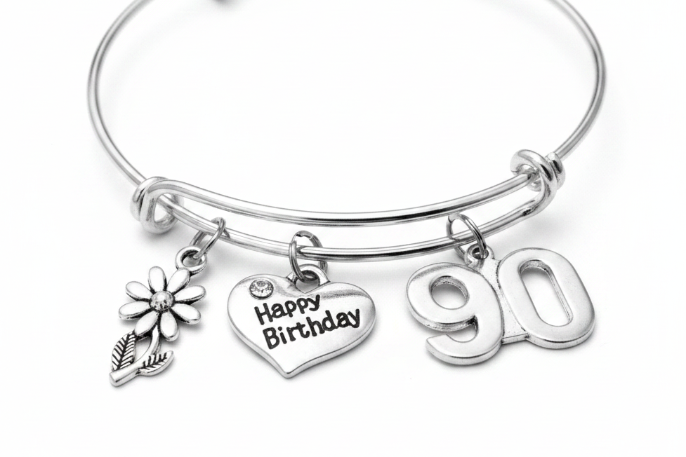 Silver expandable charm bangle bracelet with daisy flower charm, Happy Birthday heart charm with crystal accent, and bold 90 number charm, displayed on white background — 90th birthday gift for women by Jules Obsession