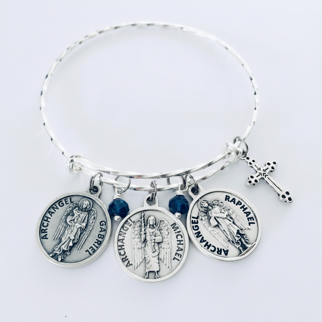 Silver twisted hammered bangle bracelet with three archangel medal charms — Gabriel, Michael, and Raphael — deep blue crystal beads, and ornate cross charm on white studio background