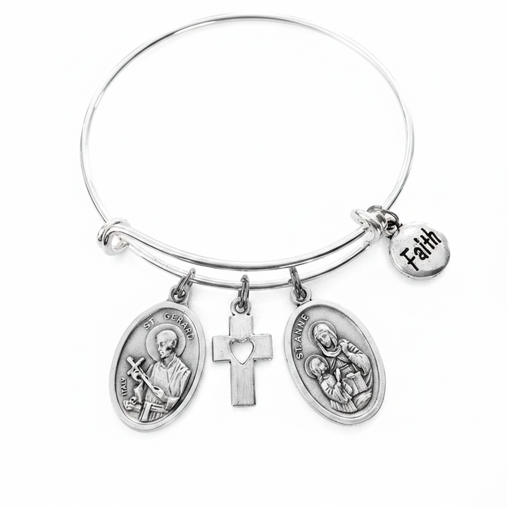 Silver expandable bangle bracelet with Saint Gerard Italy oval medal, heart cross charm, Saint Anne oval medal, and Faith disc charm — Catholic fertility and pregnancy gift jewelry by Jules Obsession