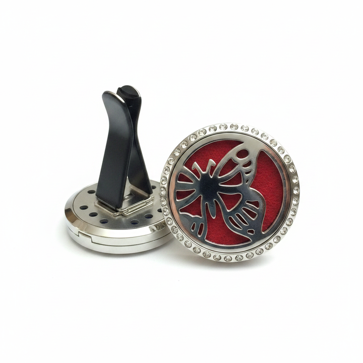 Silver butterfly essential oil car diffuser locket with crystal rhinestone border and red felt pad on white background