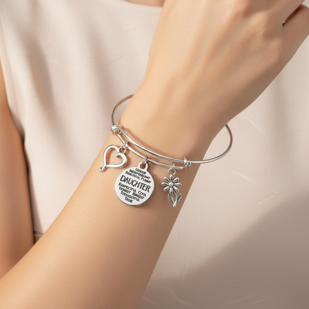 Woman wearing silver expandable Daughter charm bangle bracelet with heart, daisy, and engraved quote charms – meaningful jewelry by Jules Obsession