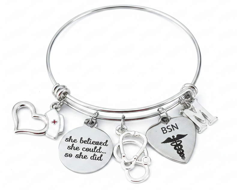 Silver expandable stainless steel bangle bracelet with BSN nurse-themed charms including BSN engraved heart with caduceus, stethoscope, nurse cap, open heart, inspirational disc charm reading she believed she could so she did, Bachelor of Science in Nursing
