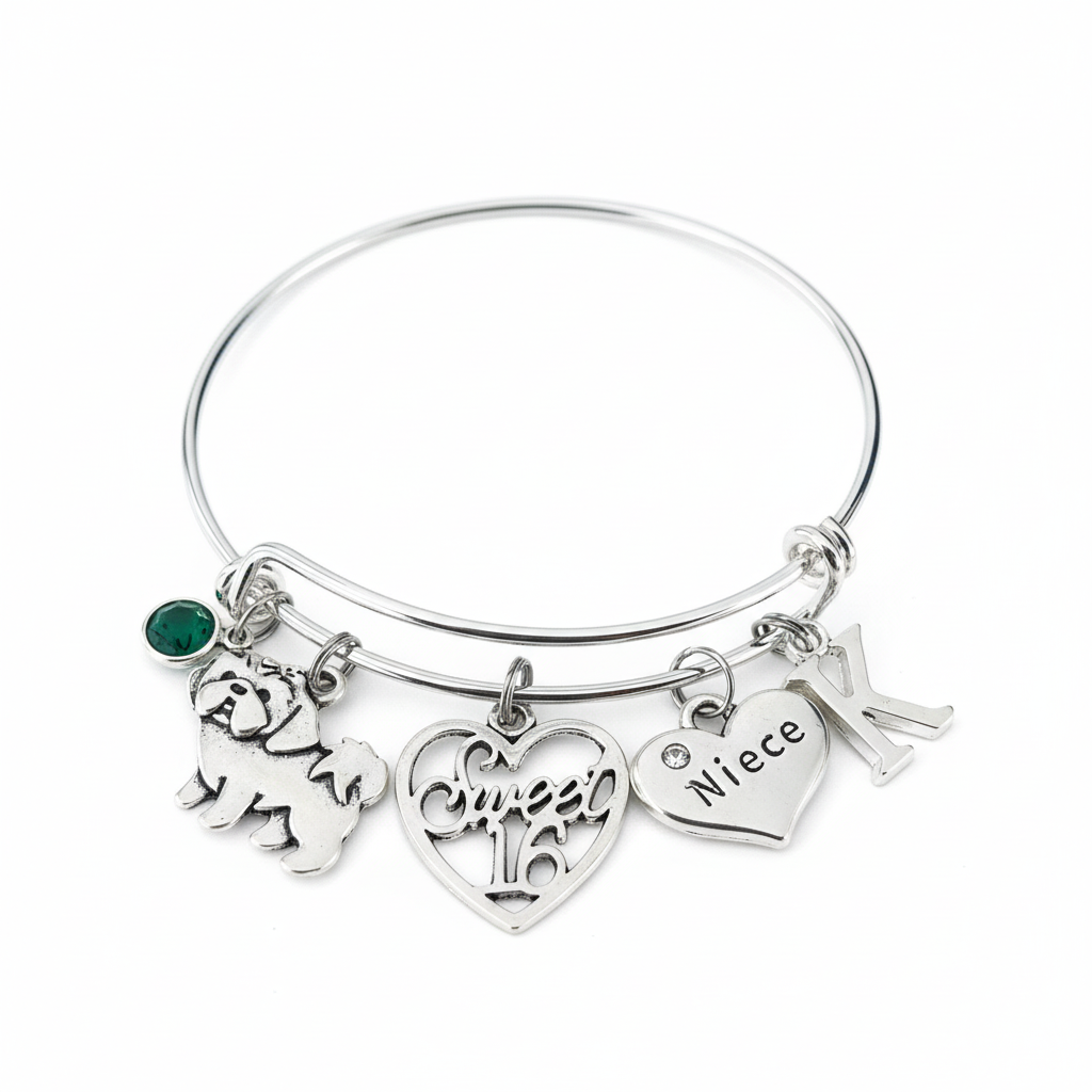 Silver expandable bangle bracelet with green birthstone crystal, Shih Tzu dog charm, Sweet 16 open-work heart charm, Niece crystal heart charm, and letter K initial charm on white background